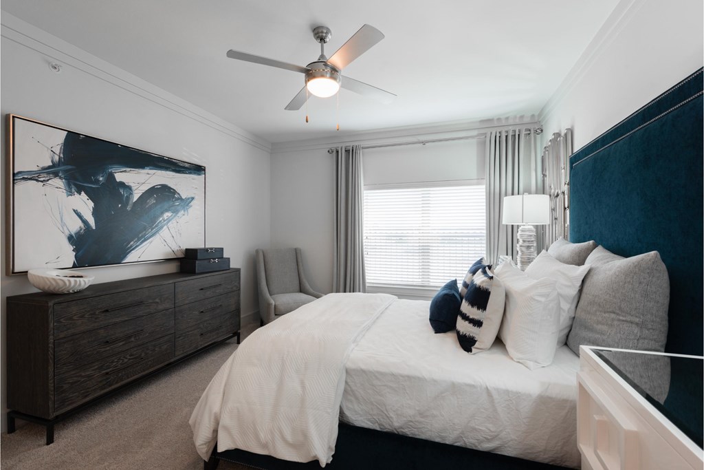 a bedroom with a large bed and a ceiling fan