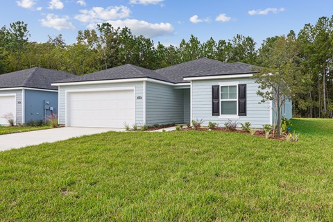 A house with a grey roof and a white garage door.