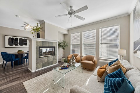 A living room with a glass coffee table and a grey sofa.