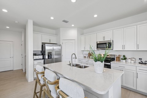 A kitchen with white cabinets and a marble countertop.