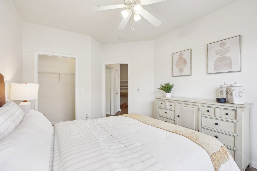 A bedroom with two beds and a ceiling fan.
