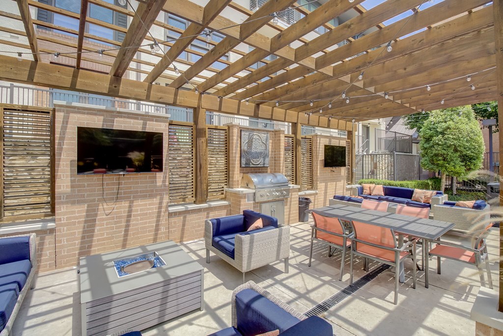 a patio with a wooden pergola and a fireplace