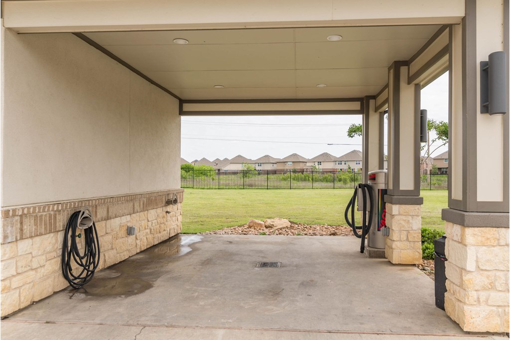 the yard of a gas station with a view of a field and houses