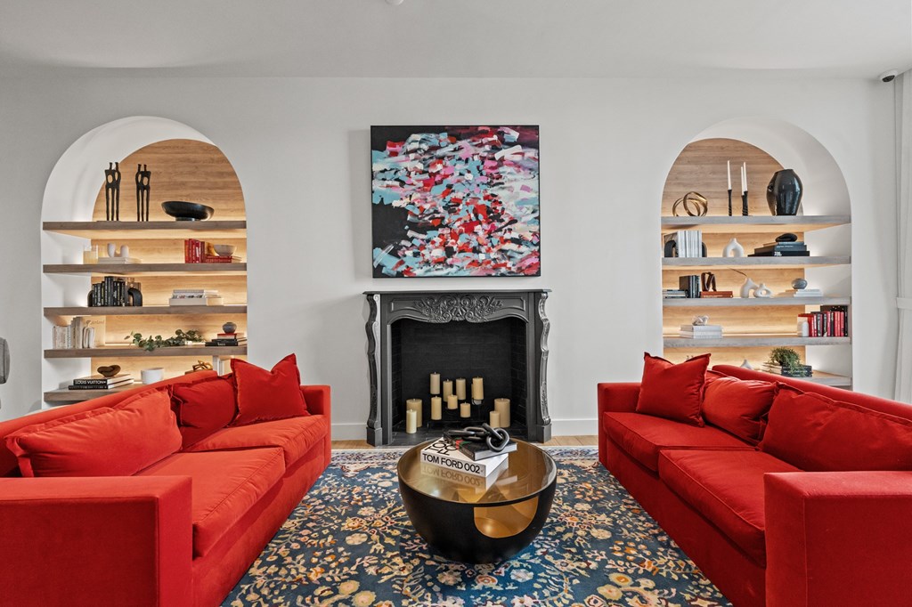 A living room with red couches and a fireplace.