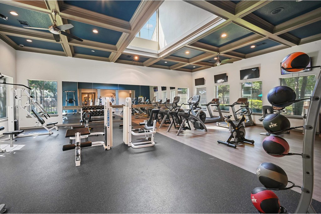 a gym with weights and other exercise equipment and windows