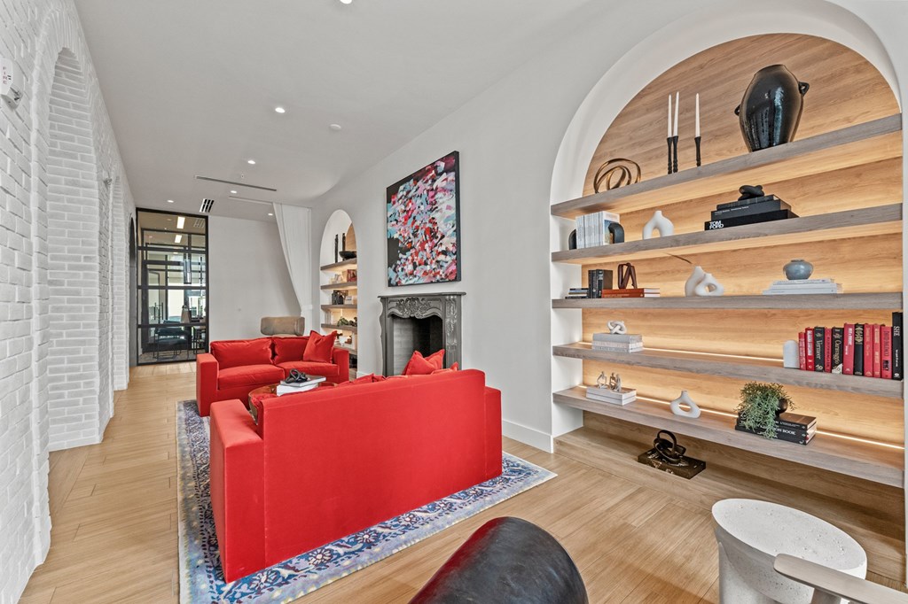 A living room with a red couch and a fireplace.