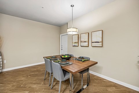 A dining room with a wooden table and grey chairs.
