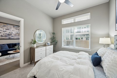 A bedroom with a large bed and a ceiling fan.