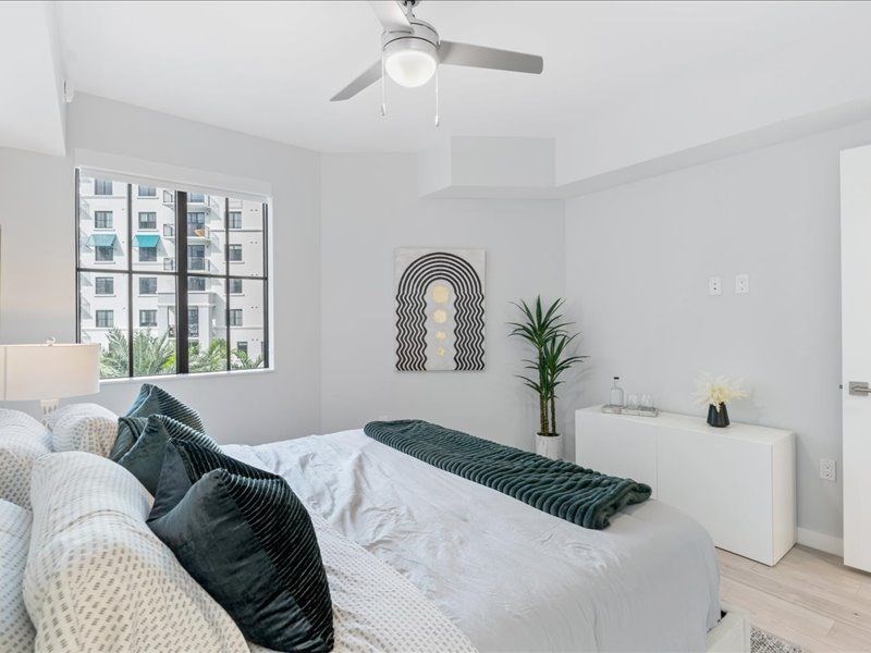 a white bedroom with a bed and a window