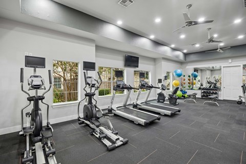 A spacious gym with treadmills, elliptical machines, and other exercise equipment.
