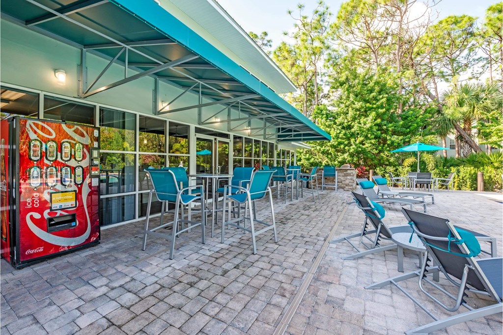 a patio with tables and chairs and a coke vending machine