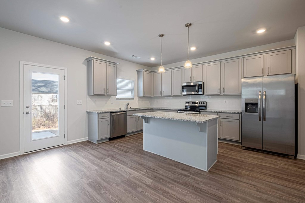 a kitchen with stainless steel appliances and a marble counter top