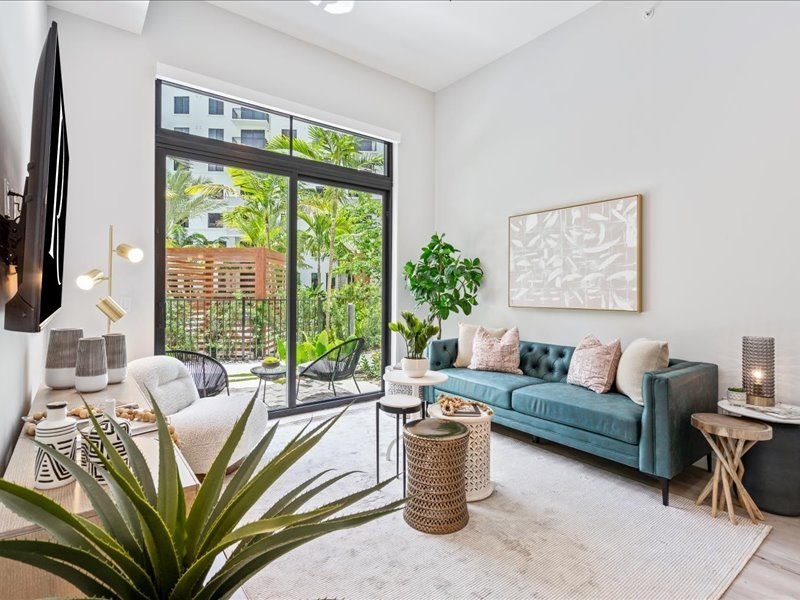 a living room with a blue couch and a large window