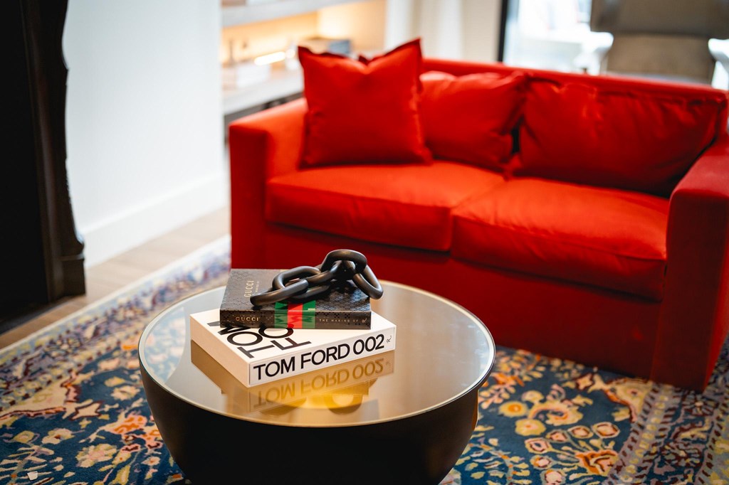 A red couch with a black coffee table in front of it.