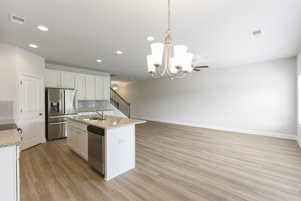 an open kitchen and living room with a chandelier