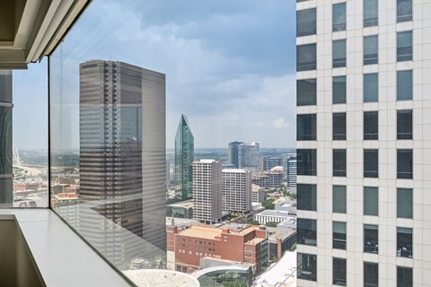 A cityscape with tall buildings and a cloudy sky.