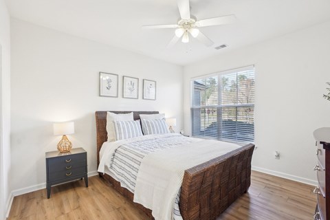 A bedroom with a large bed and a ceiling fan.