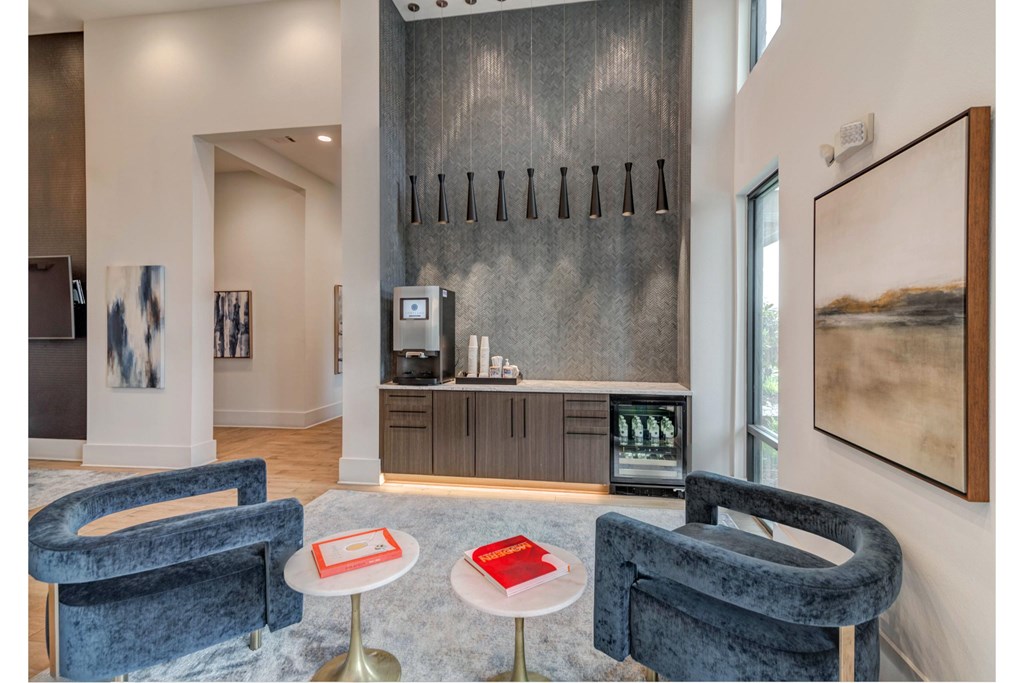 a living room with two blue chairs and a coffee table