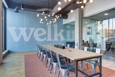 A conference room with a long table and chairs with a sign that says Welki.