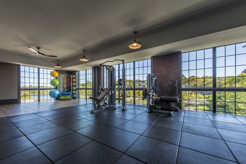 A spacious room with a tiled floor and a view of the outdoors through large windows.