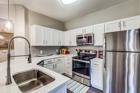 A modern kitchen with stainless steel appliances and white cabinets.
