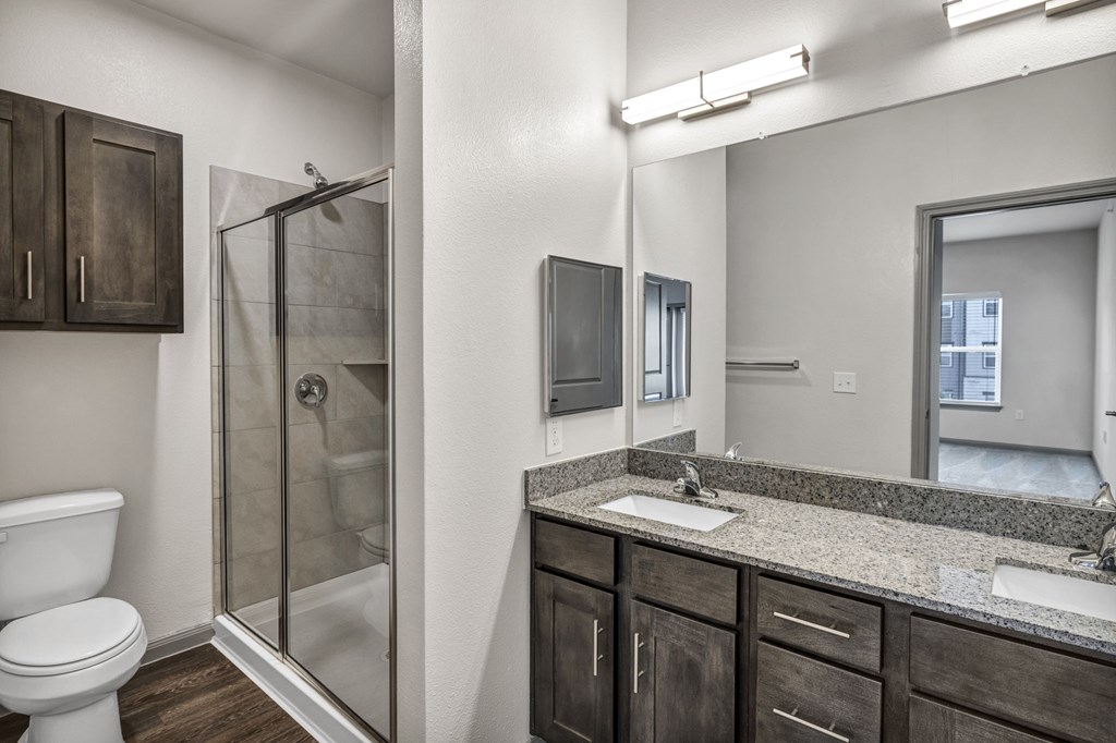 a bathroom with a shower sink and toilet and a mirror