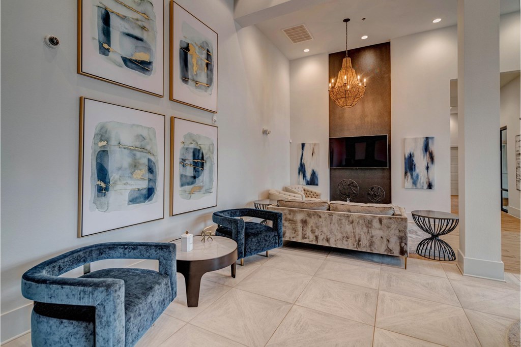 a living room with blue furniture and pictures on the wall