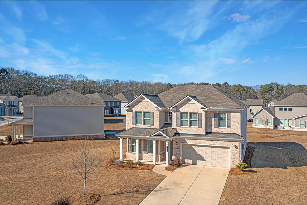 a row of houses on a field with trees in the background