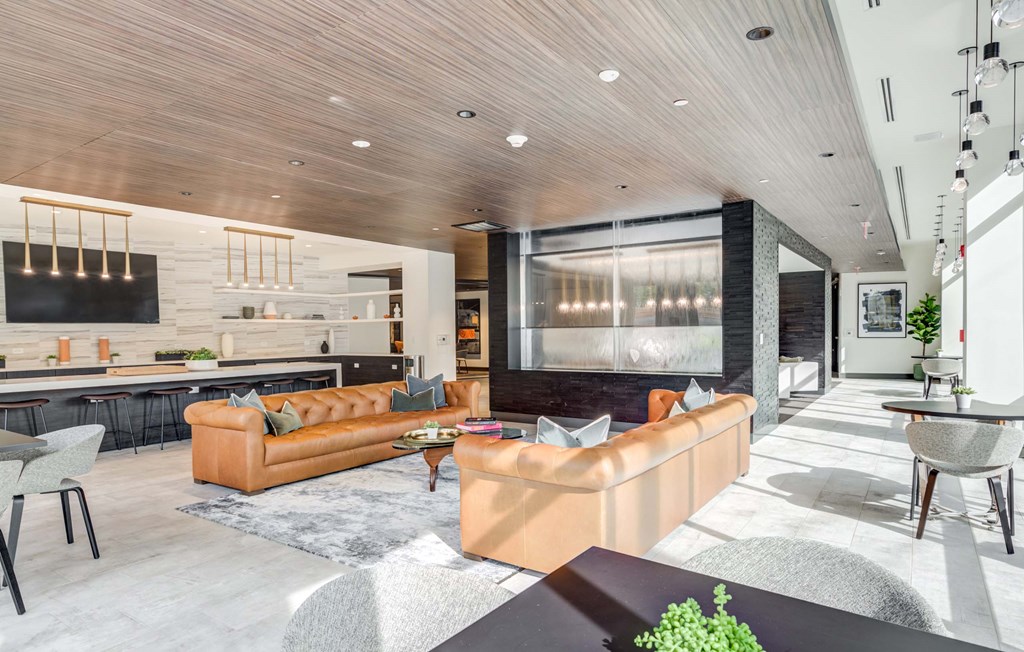 A modern living room with a large sectional sofa and a bar area.