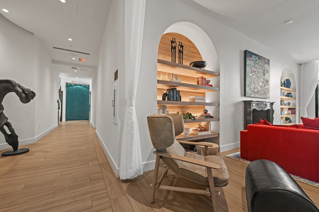 A living room with a red couch and a wooden floor.