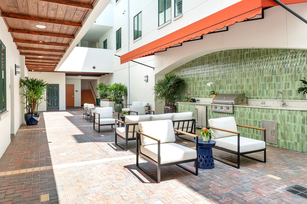 a patio with chairs and a kitchen in a building