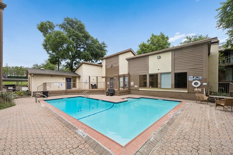 A small pool surrounded by a brick patio.