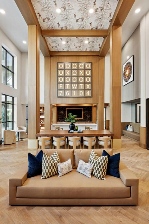 A living room with a tan couch and a fireplace.