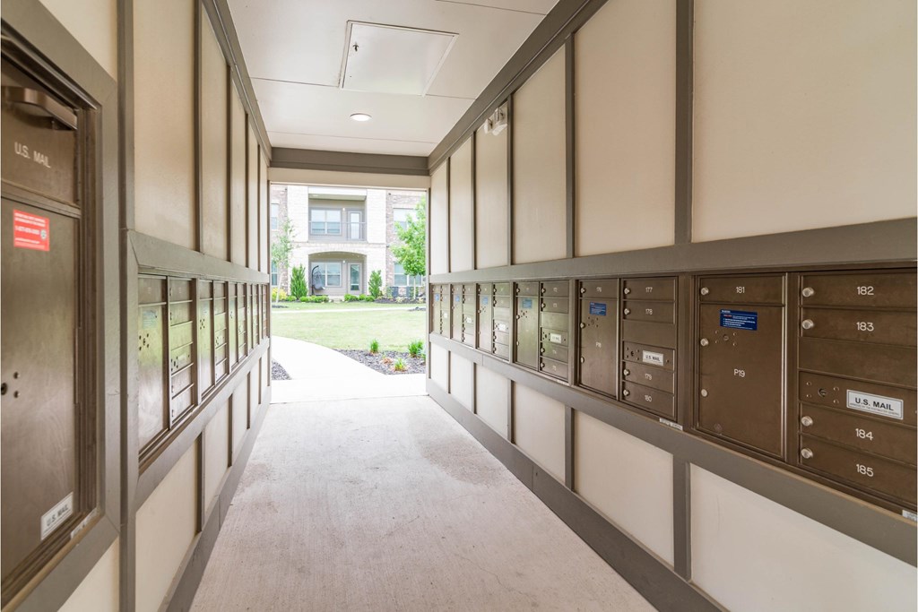 a hallway with mailboxes and a building in the background