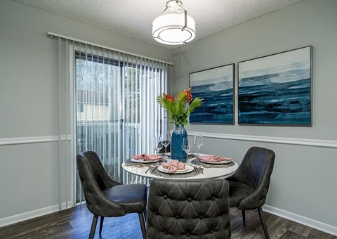 a dining room with a table and chairs and a window