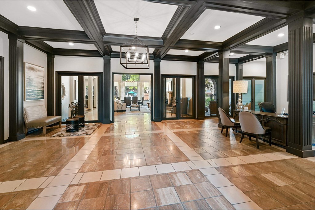 a large lobby with chairs and a table and a chandelier