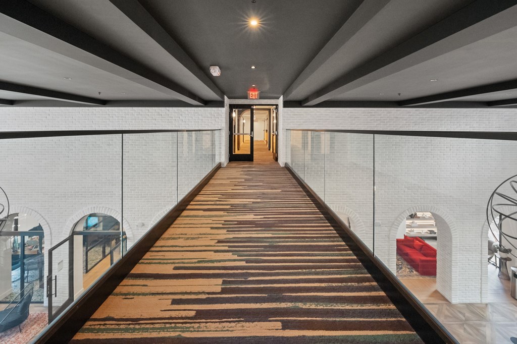 A long hallway with a red carpet and white walls.