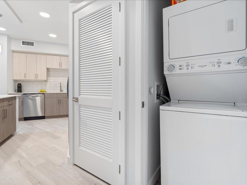 a white kitchen with a refrigerator and a washer and dryer