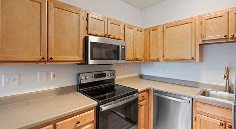 A kitchen with wooden cabinets and a black stove top oven.