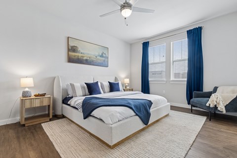 A bedroom with a large bed and a painting on the wall.