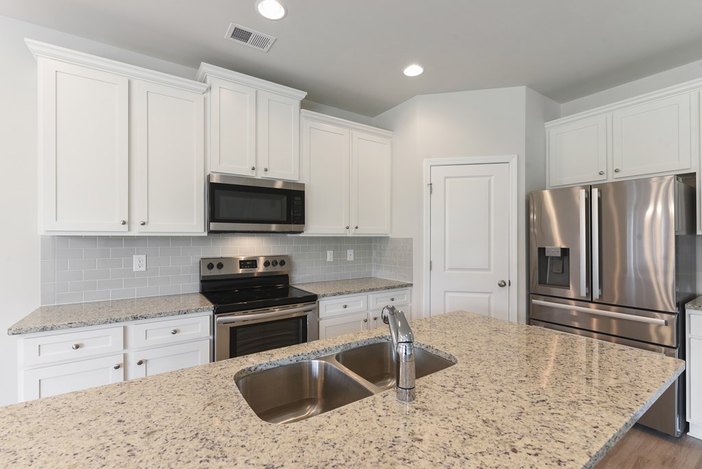 a kitchen with granite counter tops and stainless steel appliances