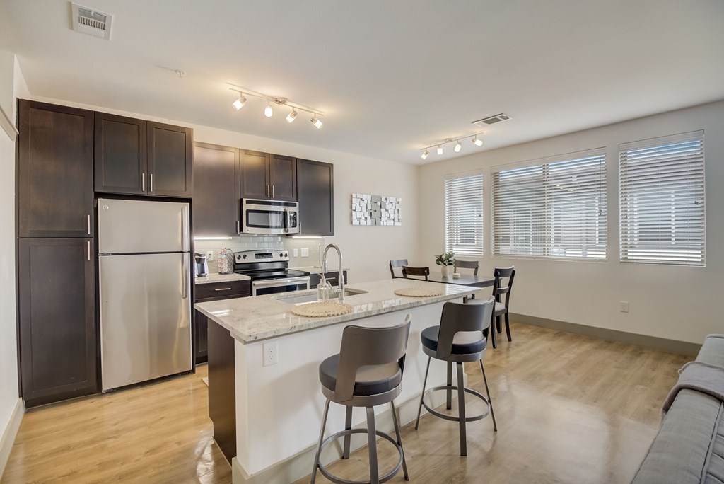 a kitchen with a large center island with a breakfast bar