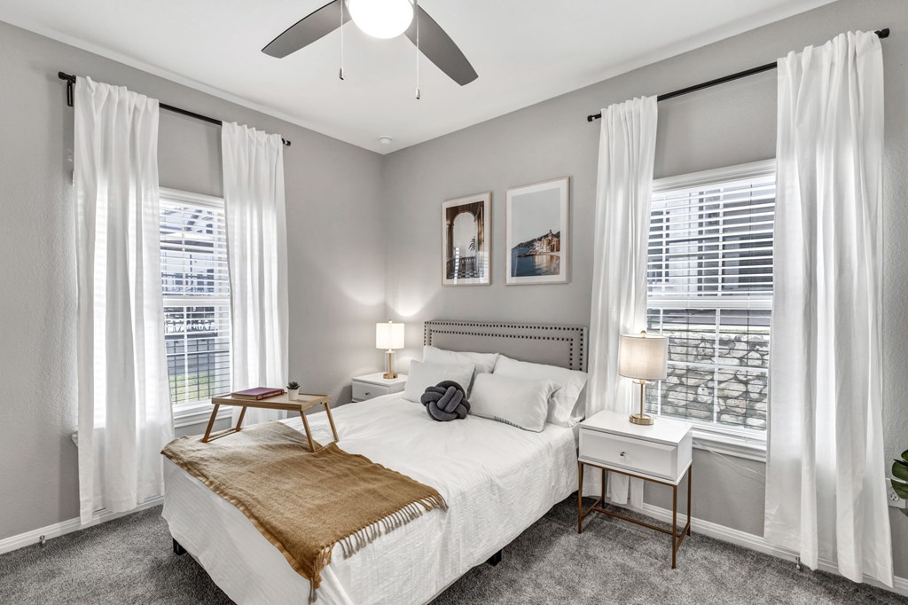 a bedroom with a bed and two windows