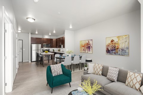 a living room with a couch and a chair and a kitchen with a table