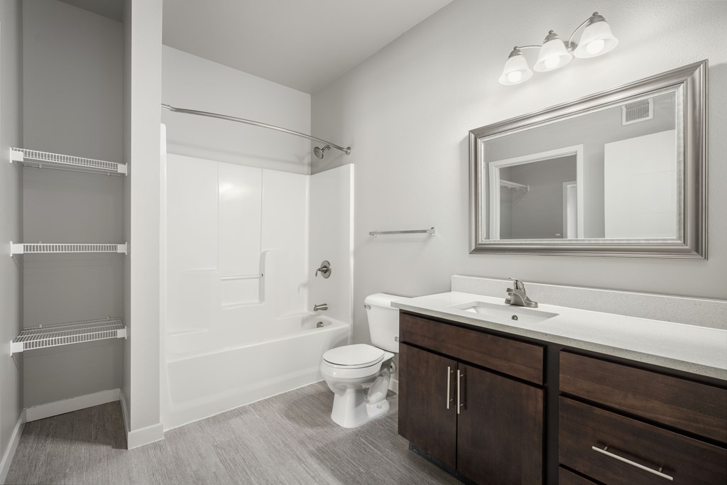 a bathroom with a toilet sink and shower and a mirror