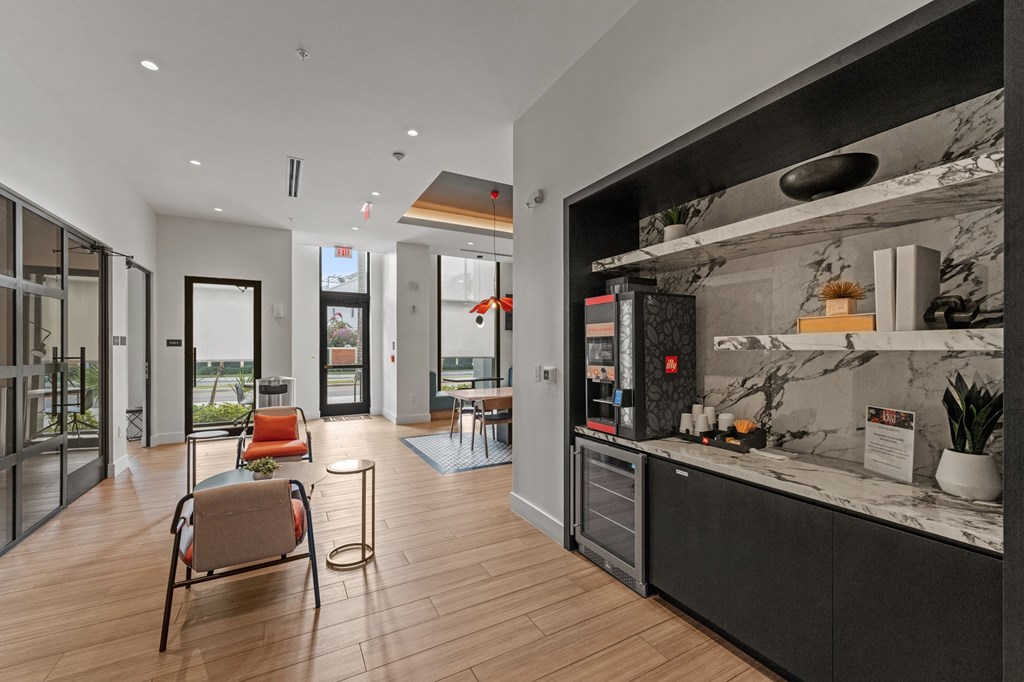 A modern kitchen with a marble countertop and a seating area with chairs and a table.