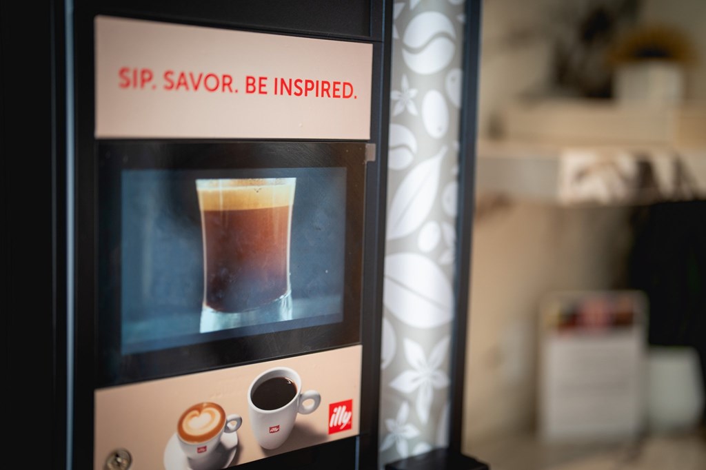 A coffee vending machine with the words "Sip. Savor. Be Inspired." on it.