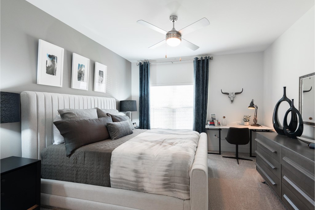 a bedroom with a bed and a ceiling fan