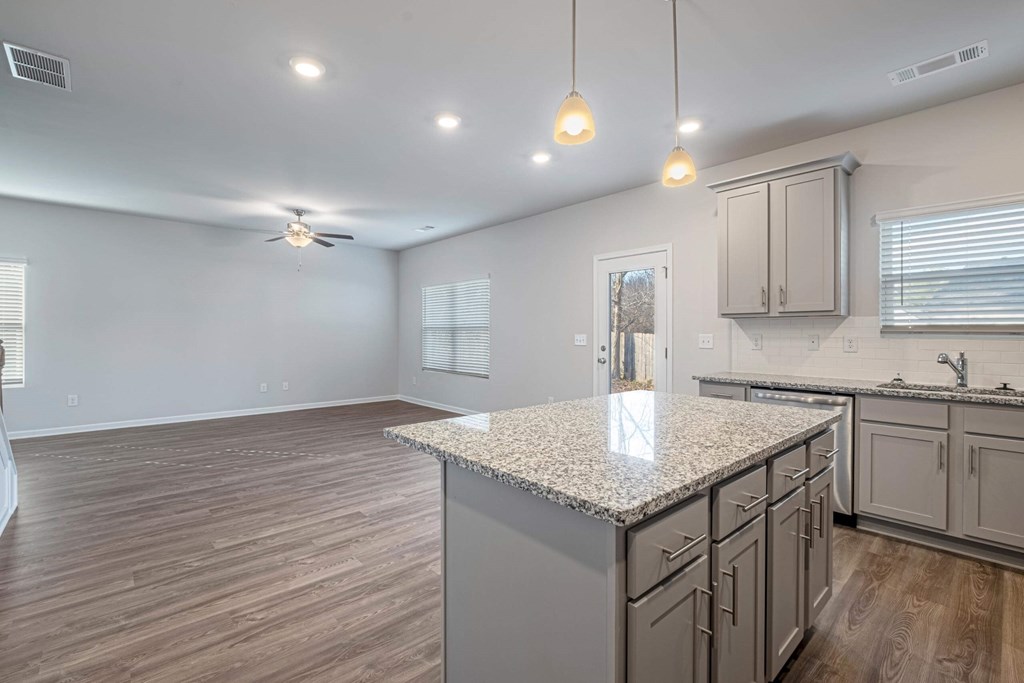 the kitchen and living room of a new home with a granite counter top