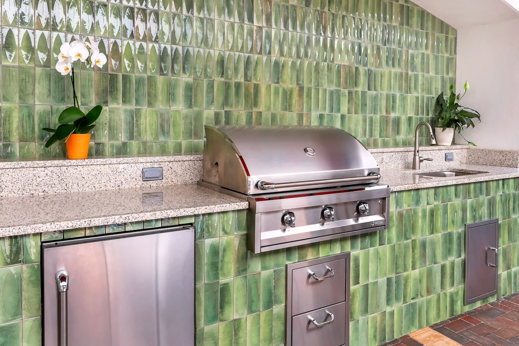 a kitchen with a stainless steel grill and a sink